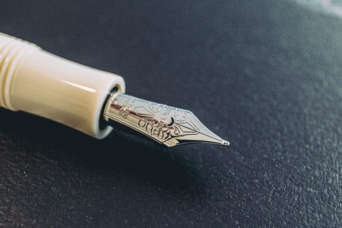 Penna stilografica Canova in resina avoriata con firma Canova sul cappuccio e incisioni scrimshaw sul fusto.